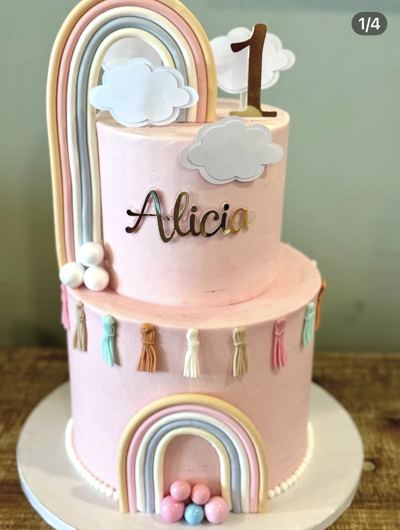 Arco-Íris Pastel — Dois andares rosa com arco-íris em tons pastel, nuvens, borlas decorativas e bolas de açúcar.