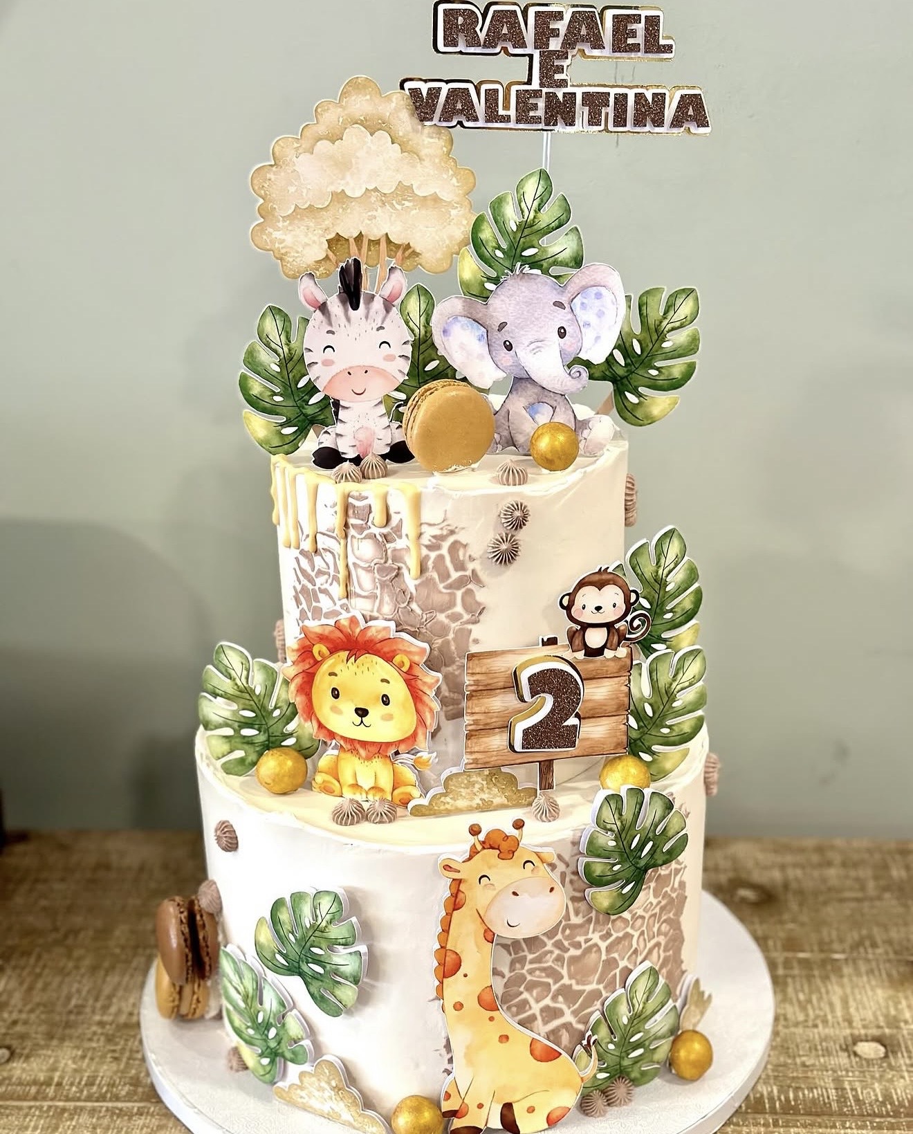 Safari Gémeos — Dois andares com leão, girafa, macaco, folhas monstera e detalhes dourados para gémeos.